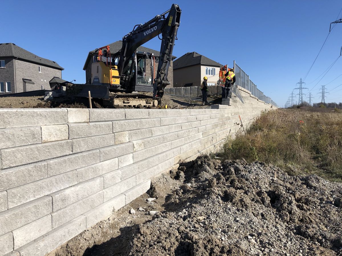 Precast retaining wall under construction with heavy machinery