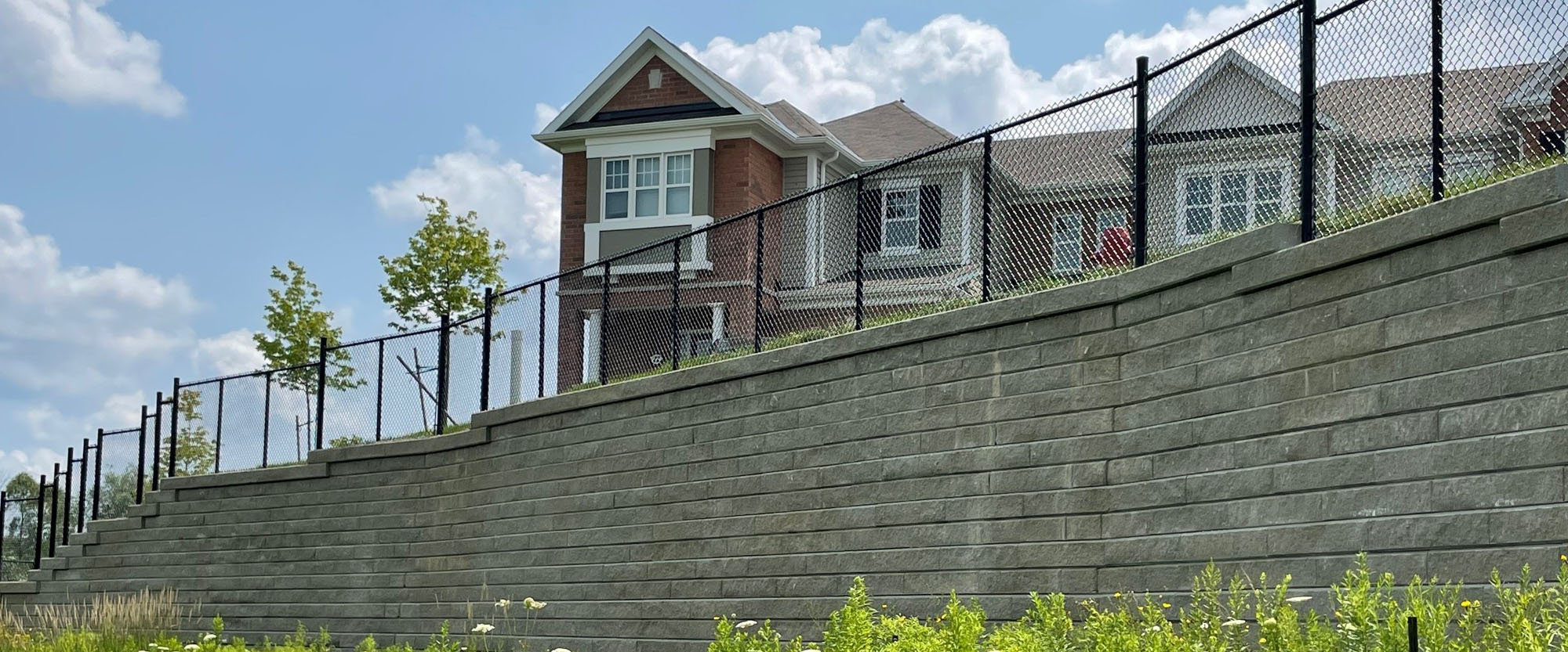 Retaining wall built around subdivision with fence
