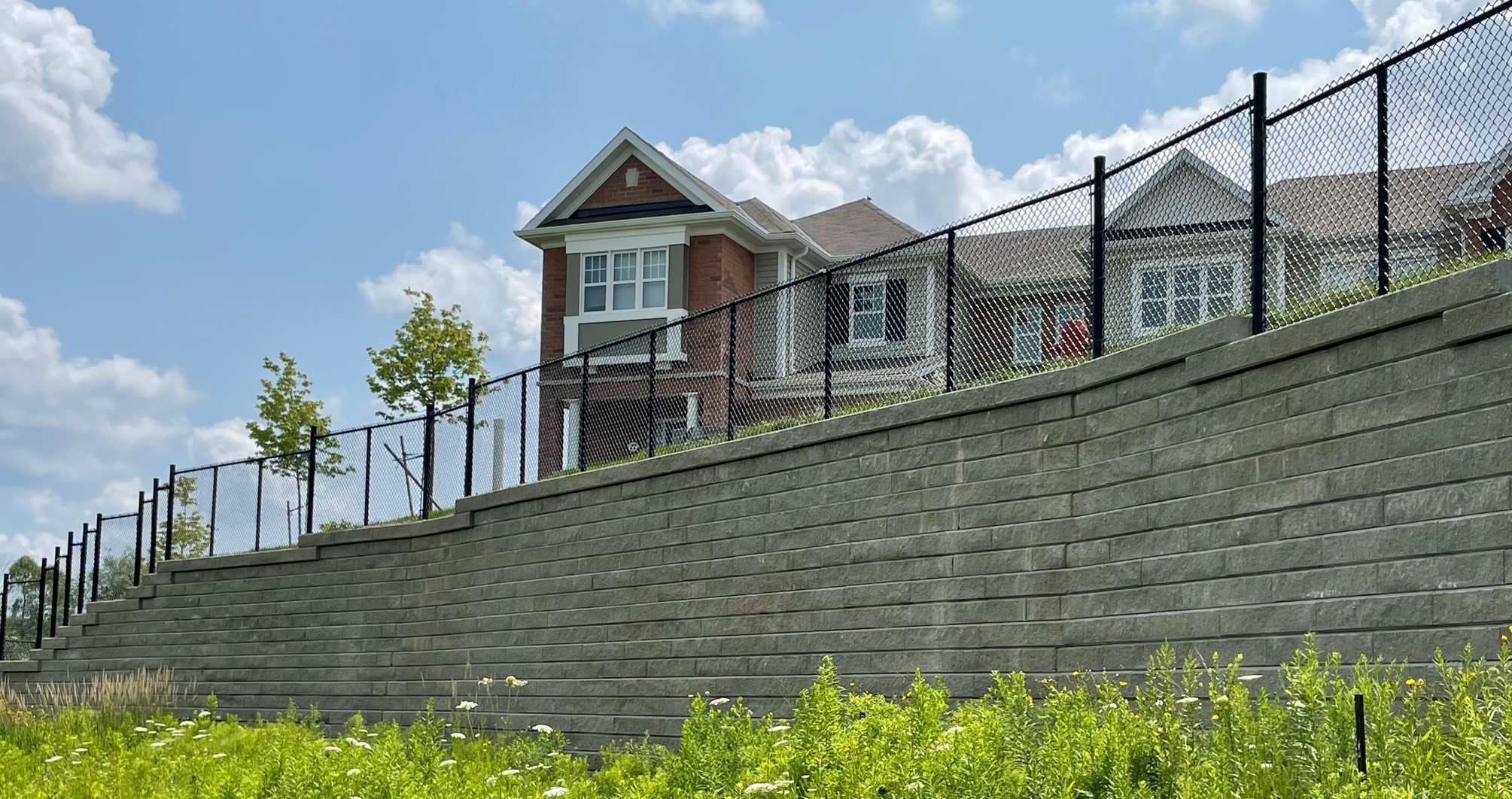 Retaining wall built around homes with fence